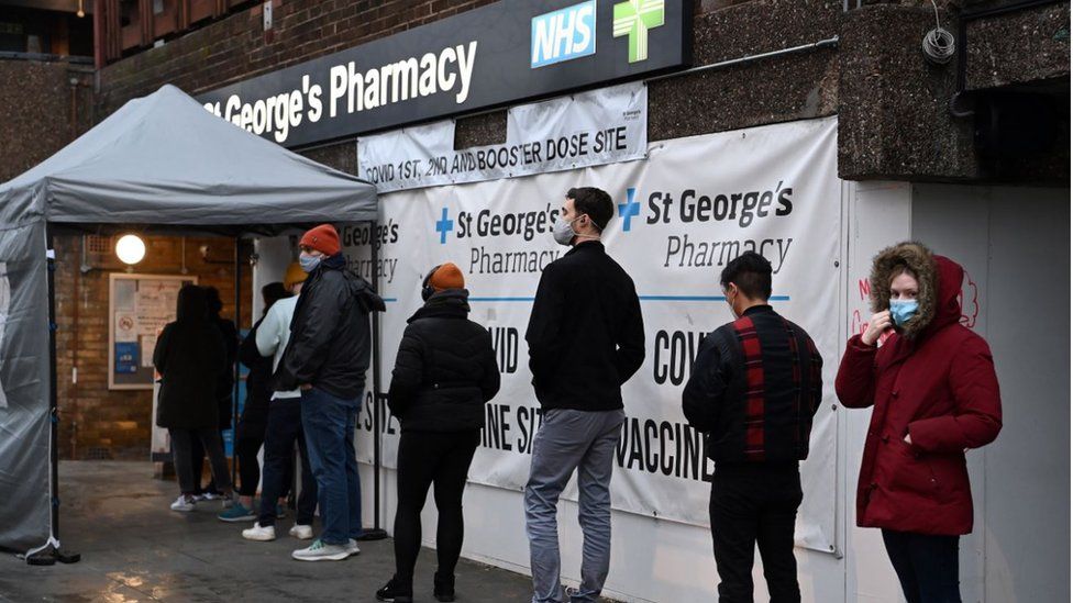 People queuing for booster jabs outside pharmacy