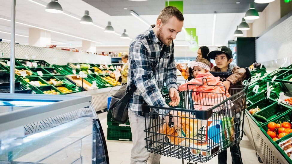 Мужчина в супермаркете с двумя детьми