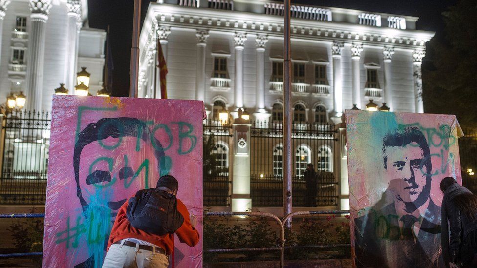 Protesters throw balloons filled with paint on portraits depicting former Prime Minister and ruling party leader Nikola Gruevski (L) and Macedonia's President Gjorgje Ivanov (R), set up in front of the government building, in Skopje on April 27, 2016, following anti-government protests dubbed the 'Colorful Revolution'.
