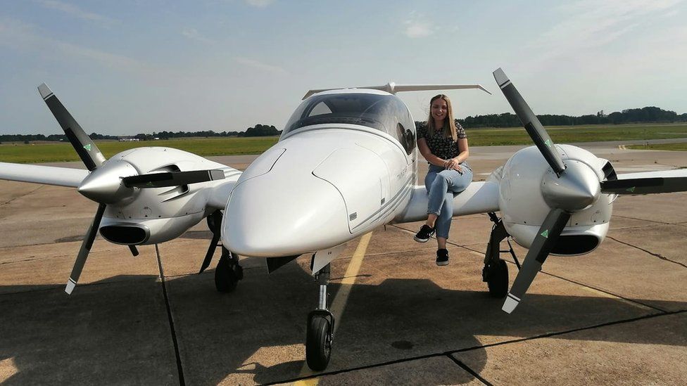 Bethan Haley sits on the wing of her Diamond DA42 aircraft in Sweden