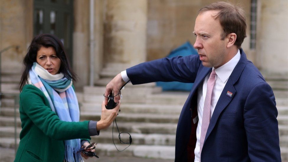 Matt Hancock hands a microphone to his aide Gina Coladangelo, following a television interview outside BBC"s Broadcasting House in London, Britain, May 16, 2021