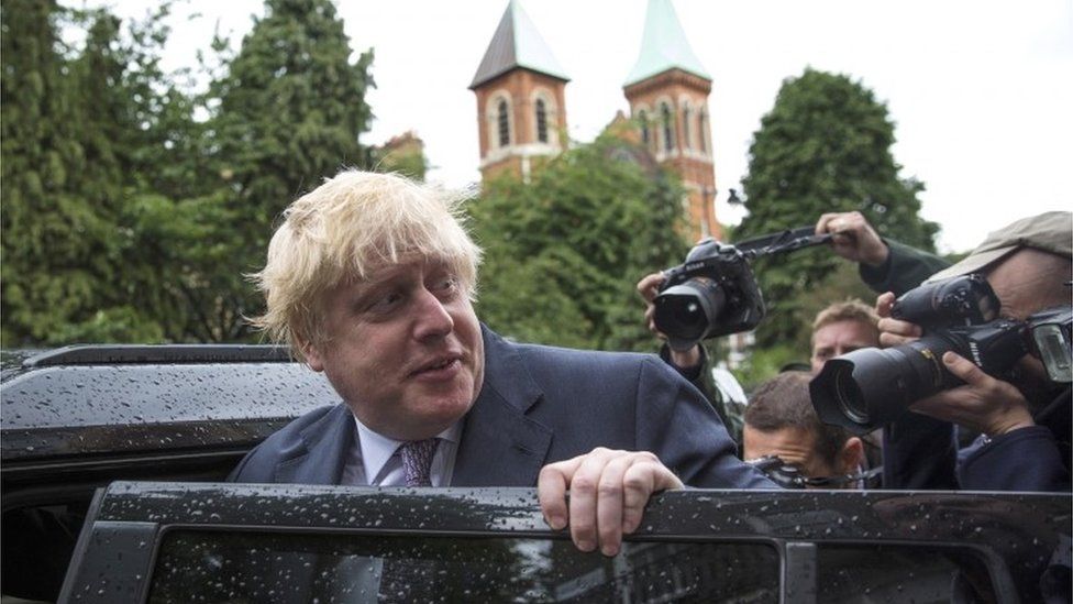 Boris Johnson followed by photographers
