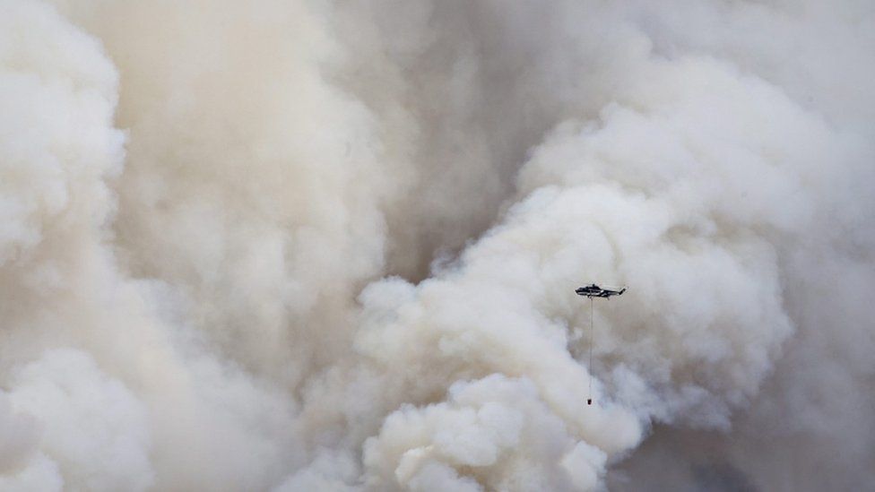 A helicopter battles the huge wildfire in Fort McMurray