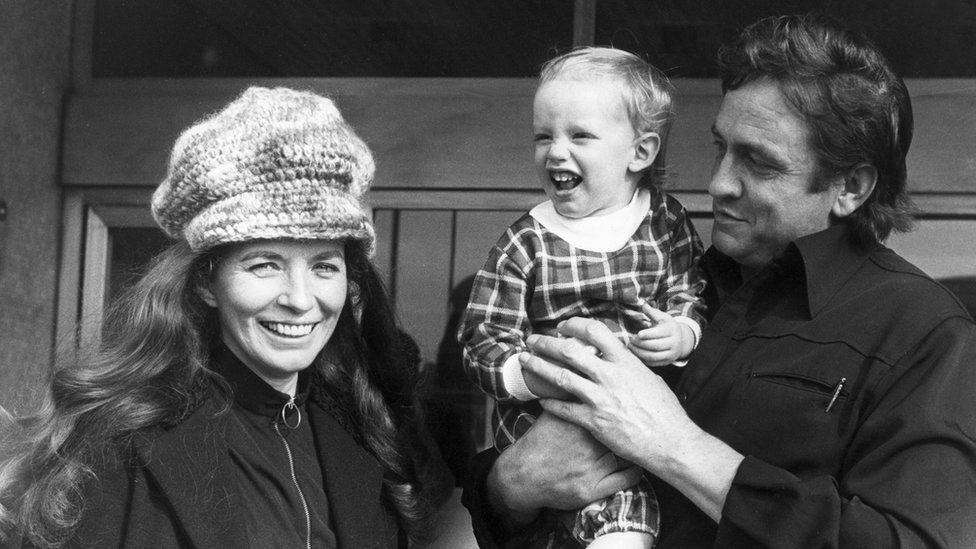Johnny Cash and his wife June pose with their eighteen month-old son John in Glasgow in 1971