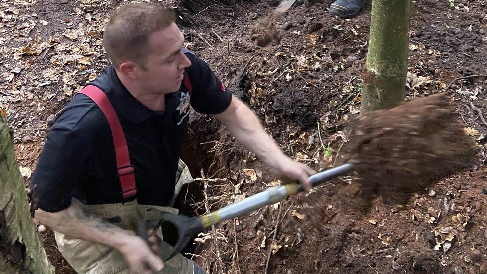 Firefighter digging in Sutton Park