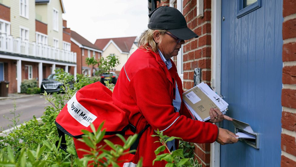 A Royal Mail post woman delivering post