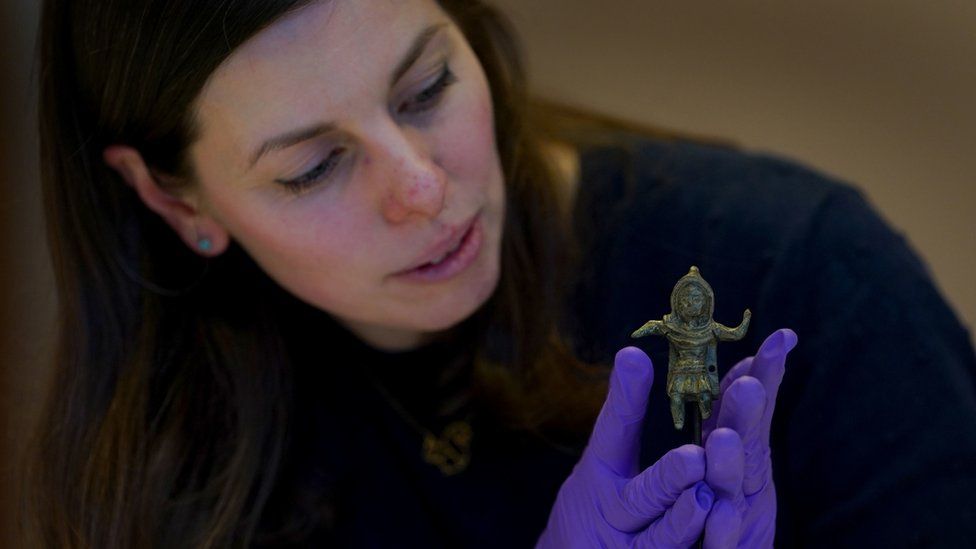 Curatorial and Learning Officer Sarah Harvey, places the Birrus Britannicus Roman figurine on display at Chelmsford Museum in Essex