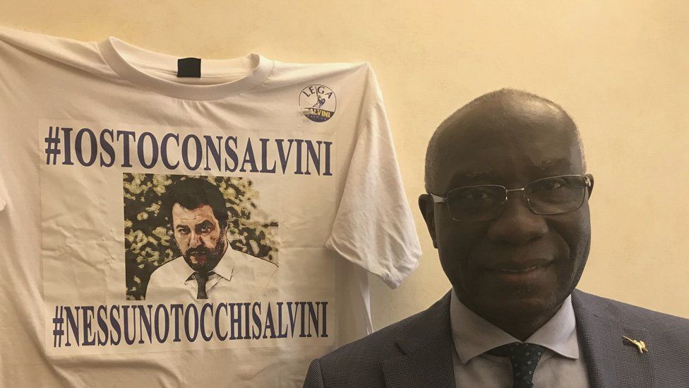 Tony Iwobi standing next to a Salvini t-shirt