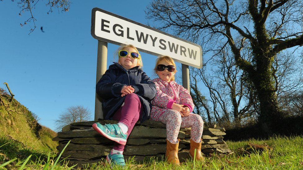 Kids by Eglwyswrw sign wearing sunglasses