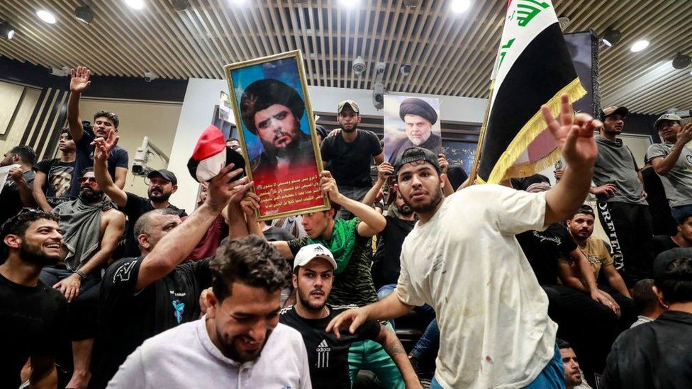 Supporters of the Iraqi cleric Moqtada Sadr raise portraits of their leader inside the country's parliament in the capital Baghdad's high-security Green Zone