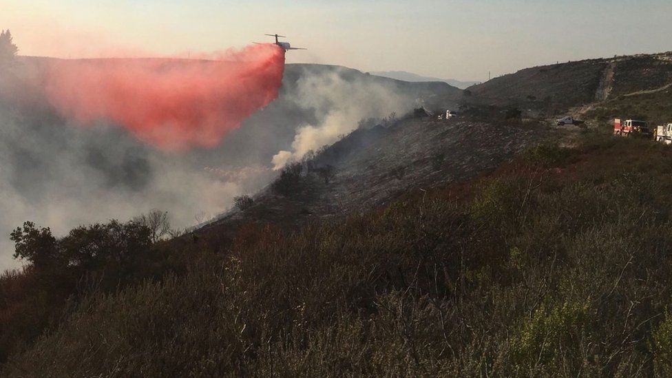 Undated photo obtained from the Santa Barbara County Fire shows firefighting tanker airplanes dropping retardant on the Thomas Fire