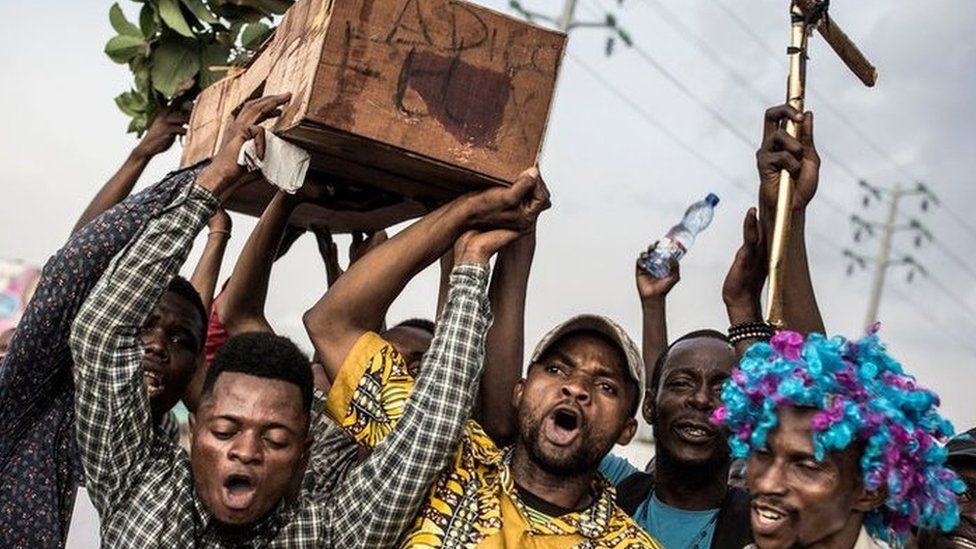Supporters of Martin Fayulu, the runner-up in Congolese elections, hold up a coffin with "Good Bye Felix" as they protest in the street on 21 January 2019 in Kinshasa, DR Congo