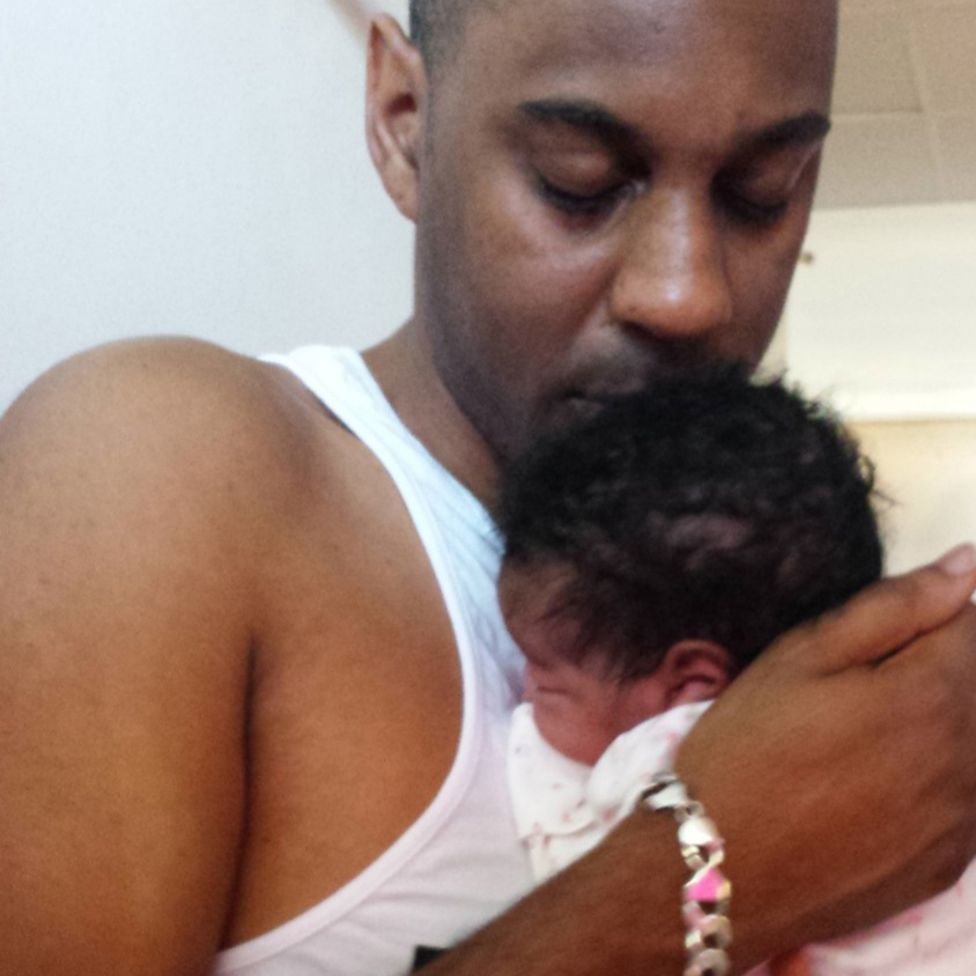 Elliott cradles his new-born daughter