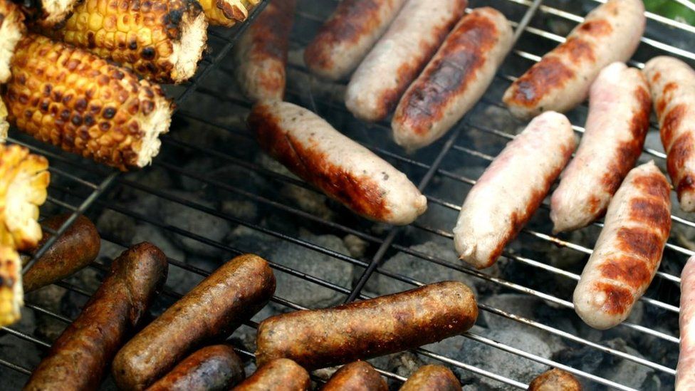 Sausages and sweetcorn on a barbecue