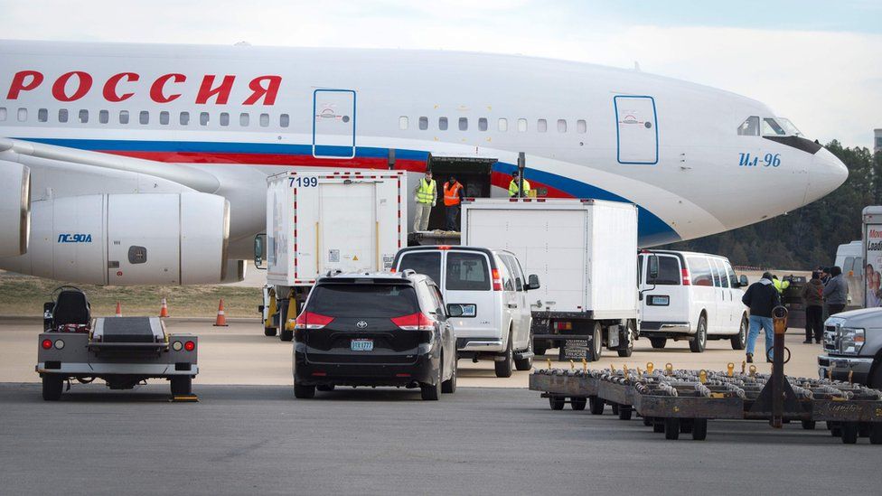 Vehicles pull up to a Russian aircraft to load freight at Dulles International Airport December 31, 2016, in Sterling, Virginia, just outside Washington, DC.
