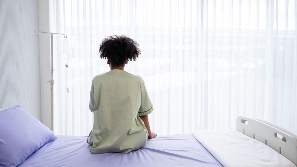 Lonely woman sat on a hospital bed