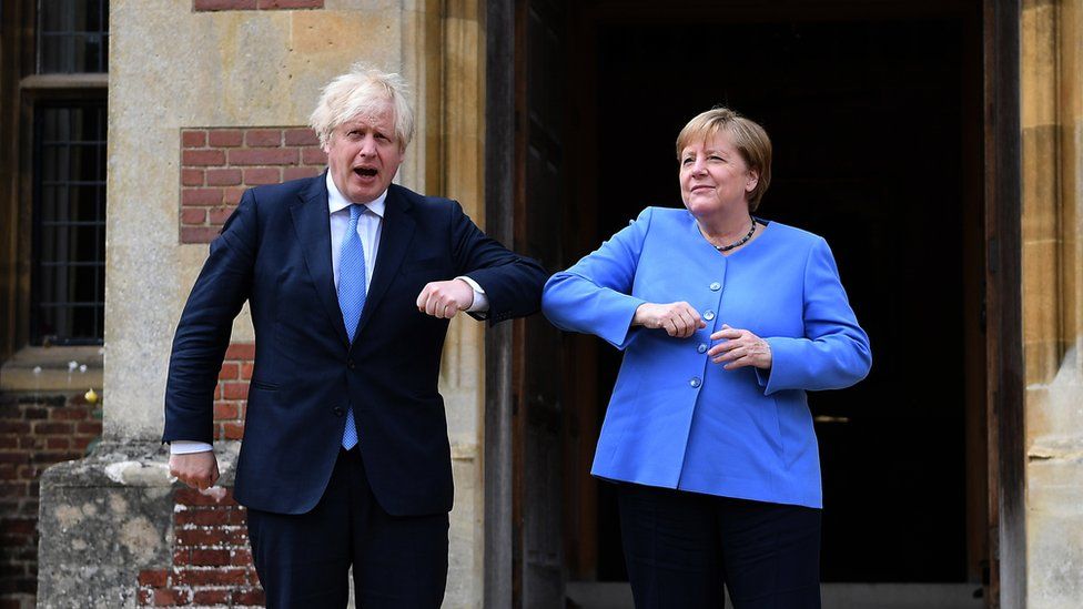 Boris Johnson (L) and German Chancellor Angela Merkel bump elbows at the prime minister's country residence at Chequers, Buckinghamshire