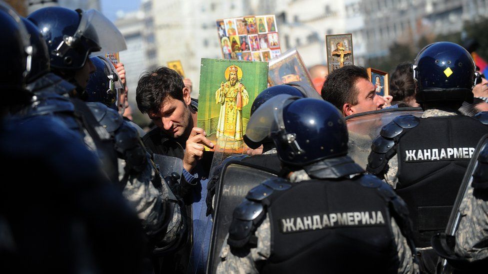 An anti-gay Serb protester holds an Orthodox icon in front of riot police in the centre of Belgrade during the country's second ever Gay Pride march on 10 October 2010