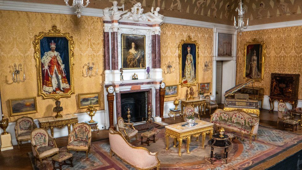 One of the rooms in the doll's house, featuring tiny royal paintings and lavish furniture
