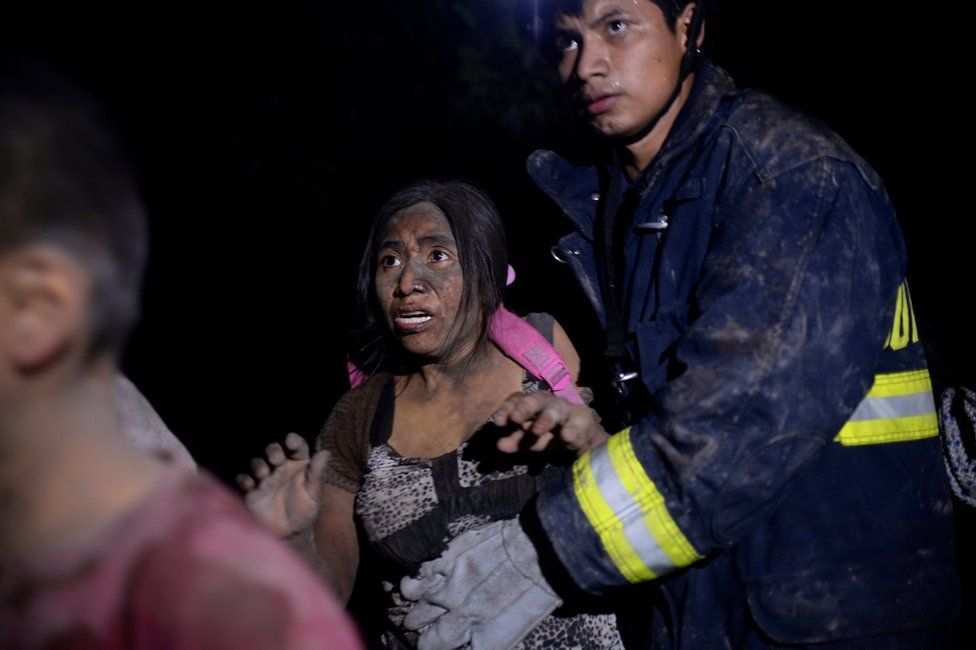 A rescue worker and a woman covered with ash