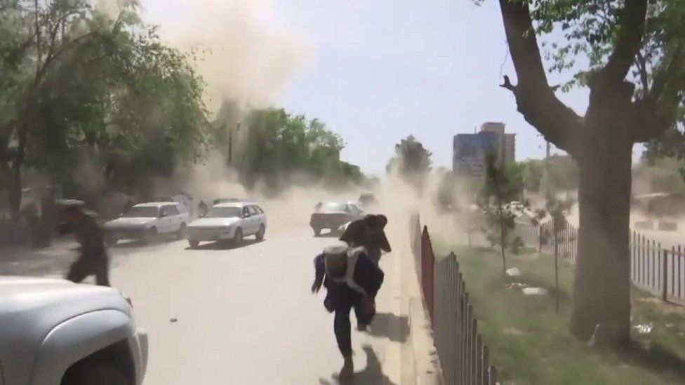 Three people flee clouds of dust at the site of the attacks