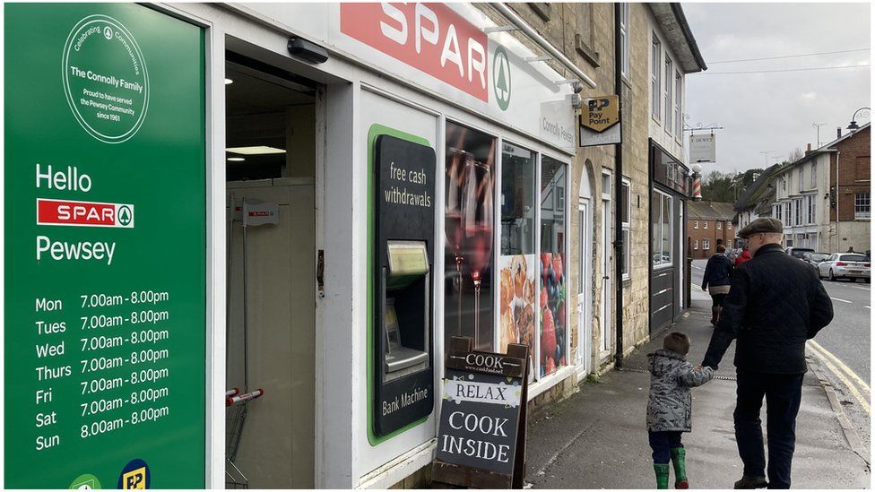 The outside of the Spar store in Pewsey with a man and a child walking past