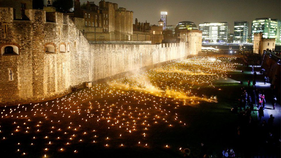 The moat of the Tower of London are seen filled with thousands of lit torches as part of the installation "Beyond the Deepening Shadow", in London,