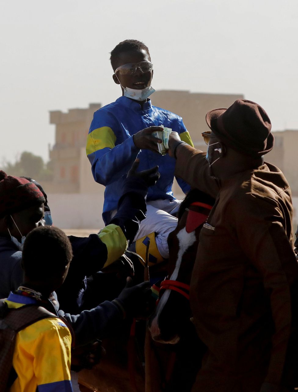 Fallou Diop is handed prize money after winning a race in Thies, Senegal, 7 February 2021