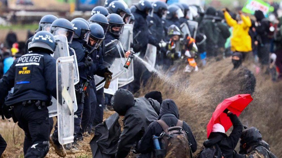 Police officers spray activists during a protest against the expansion of a German coal mine in Luetzerath