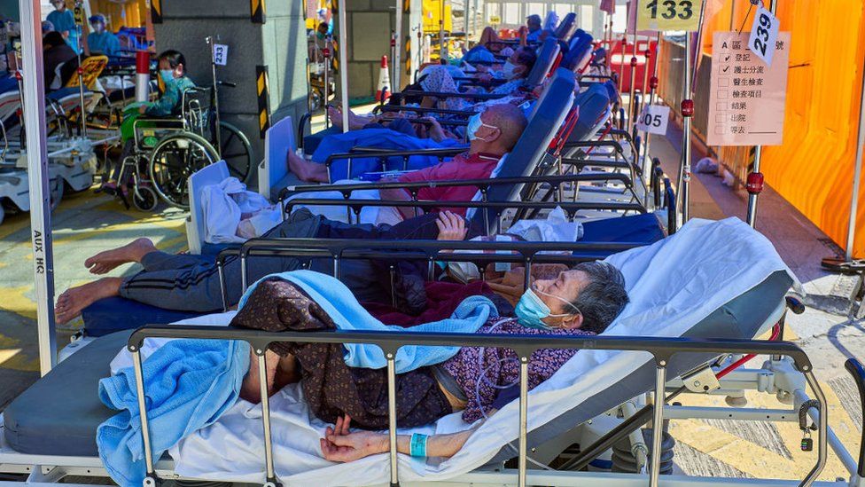Пациенты с Covid-19 лежат на кроватях возле медицинского центра Caritas в Гонконге. Больницы Гонконга переполнены, так как город столкнулся с самой страшной в истории вспышкой коронавируса.