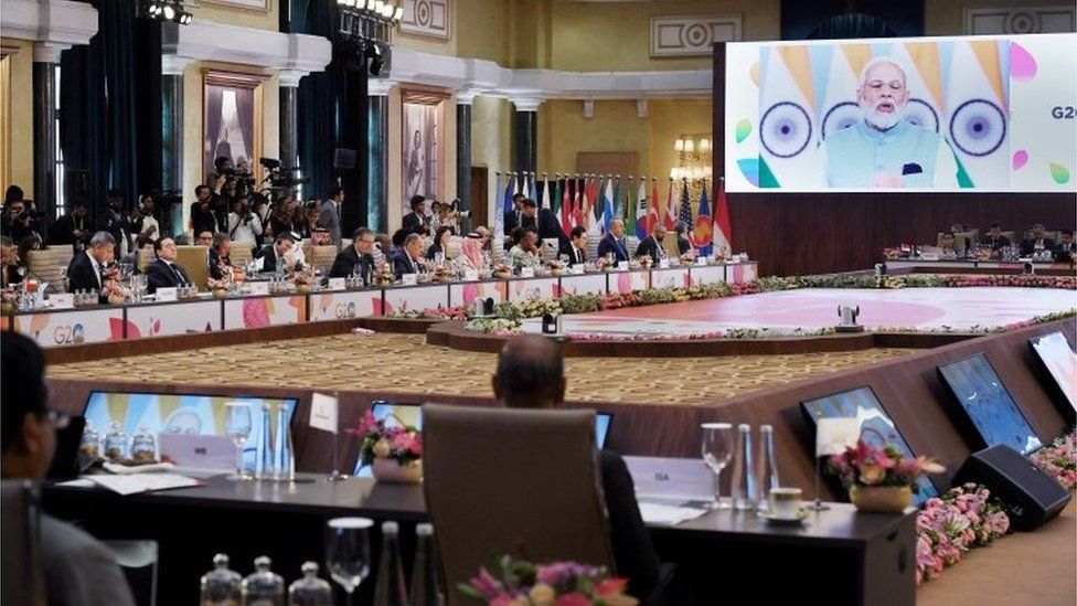India"s Prime Minister Narendra Modi (on screen) addresses the G20 foreign ministers" meeting in Delhi on March 2, 2023.