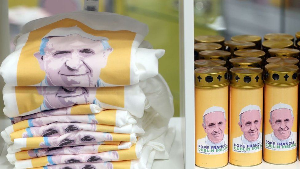 Pope Francis T-shirts and candles on sale