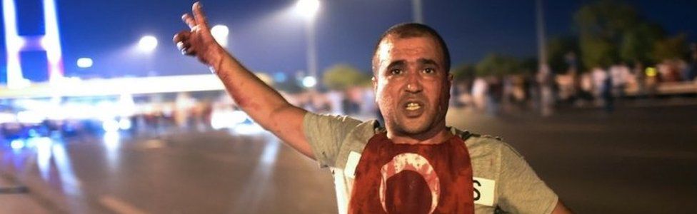 A Turkish man points to the Bosphorus bridge, July 2016