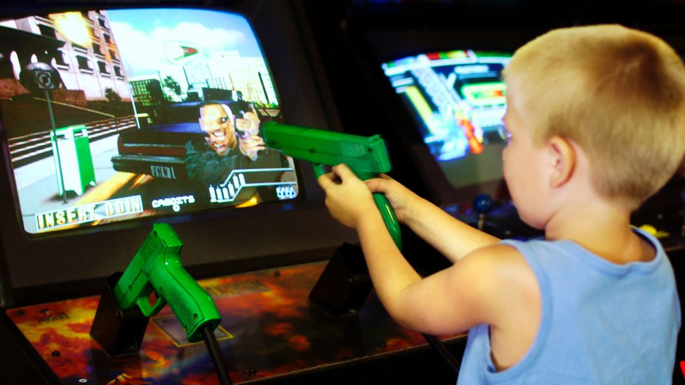Kid shooting at arcade video game