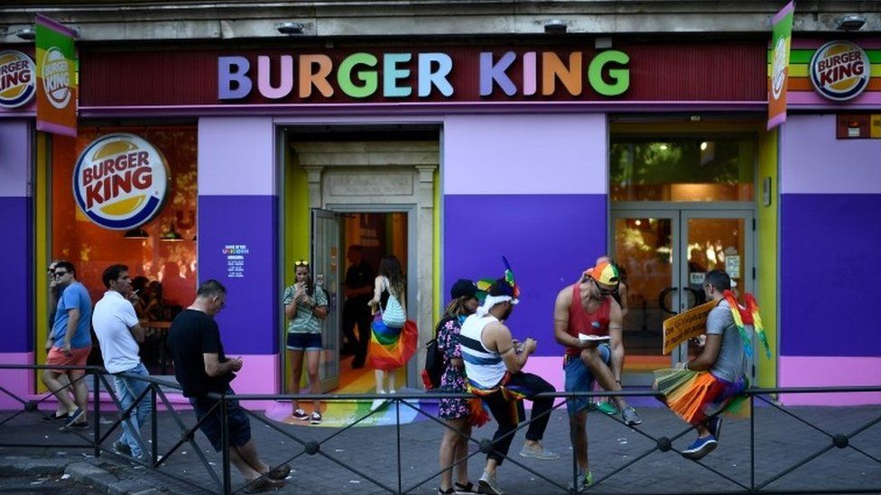 People loiter outside a Burger King during a Pride event