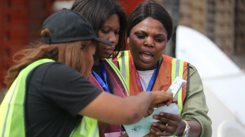 Electoral officers check a voting slip after the vote count at a polling station during the general elections, in the Ikeja district of Lagos, Nigeria, 25 February 2023.