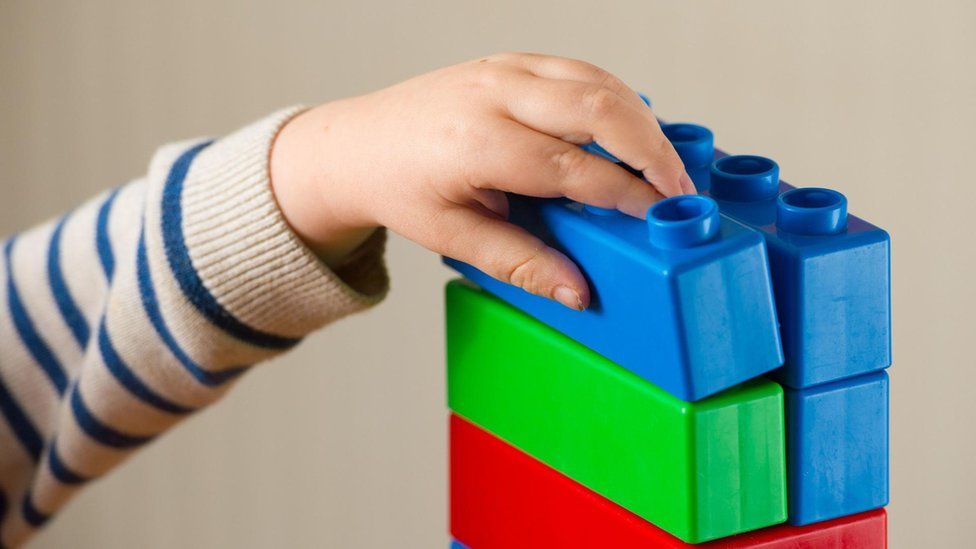 Child's hand with plastic building blocks