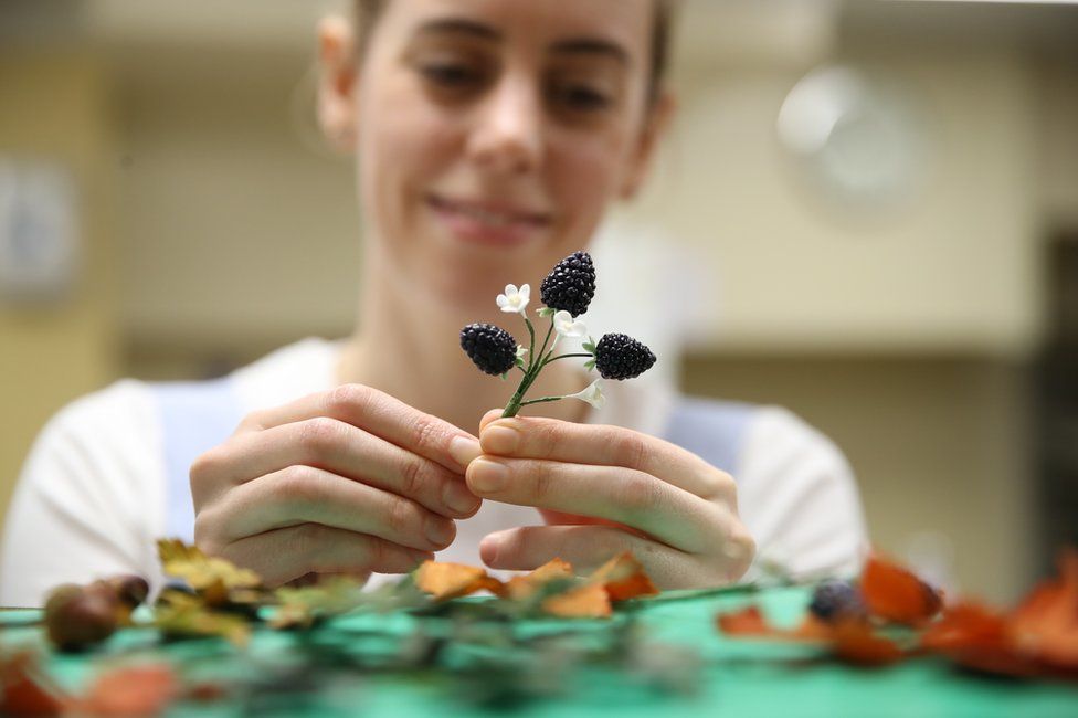 Baker Sophie Cabot puts the finishing touches to cake decorations for the red velvet and chocolate wedding cake for Princess Eugenie of York and Mr Brooksbank in the kitchens at Buckingham Palace on October 10, 2018 in London, England