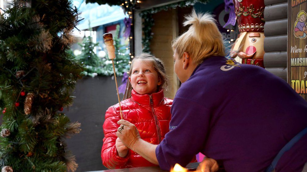 Girl is given toasted marshmallow at Christmas market 2019