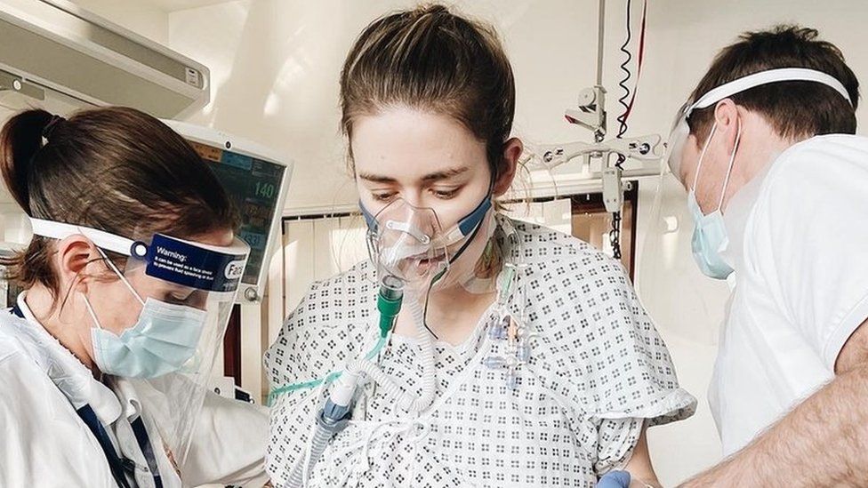 Catherine McCarroll is helped up by medics after her double lung transplant