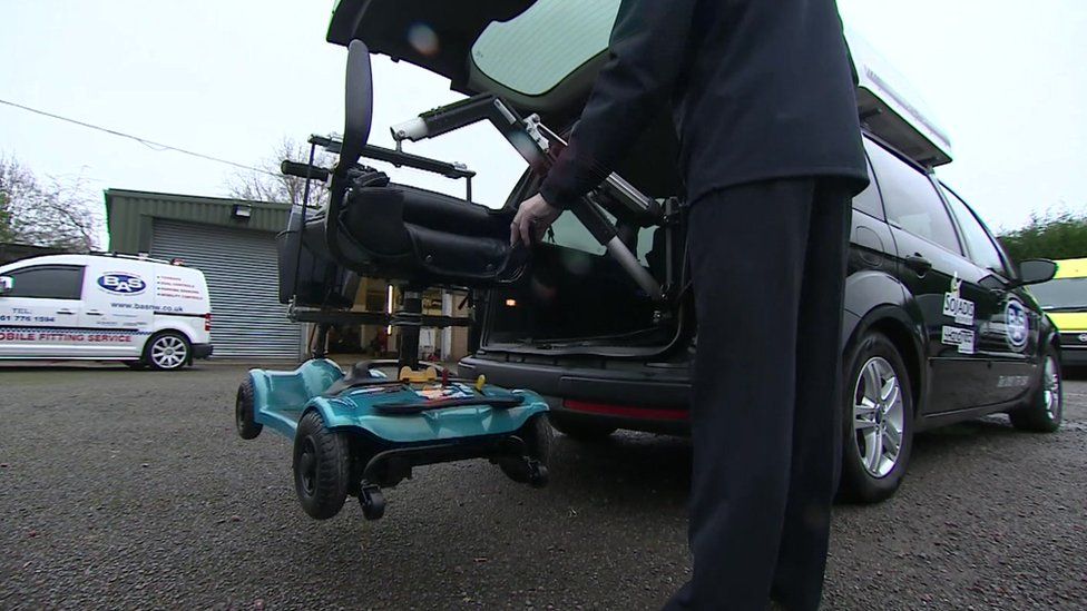 Specially-adapted Motability car lifting a wheelchair