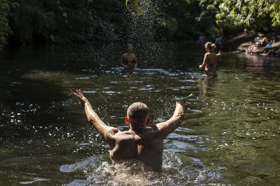 Members of the public cool off in the River Lea on May 21, 2020 in London, United Kingdom. This week temperatures reached 28 degrees celsius in the UK, as many people enjoy the sunshine despite lockdown still being in place due to the COVID-19 outbreak.