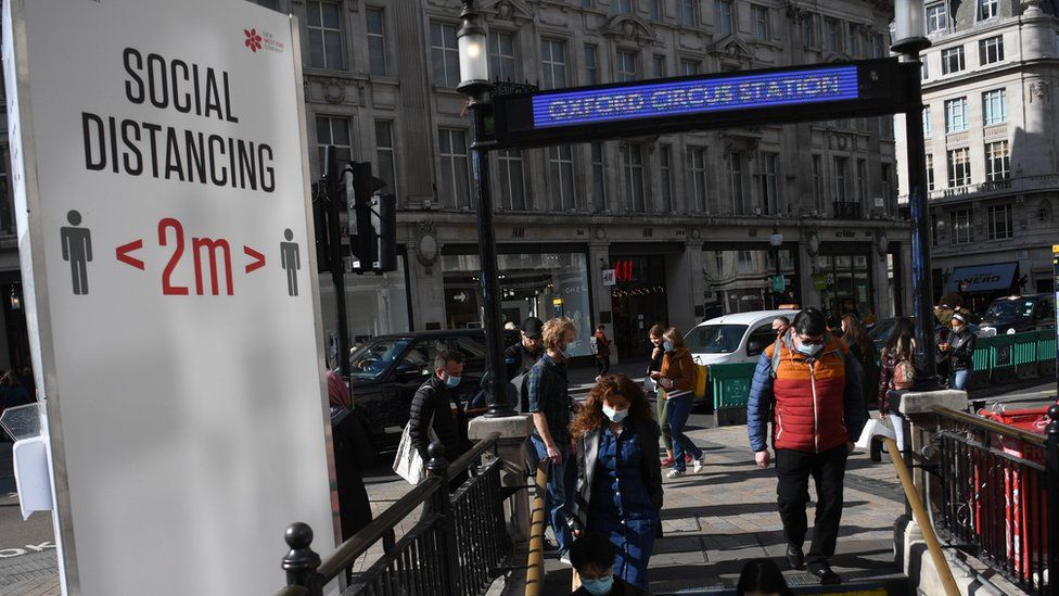 Travellers wear face masks as they enter Oxford Circus underground station