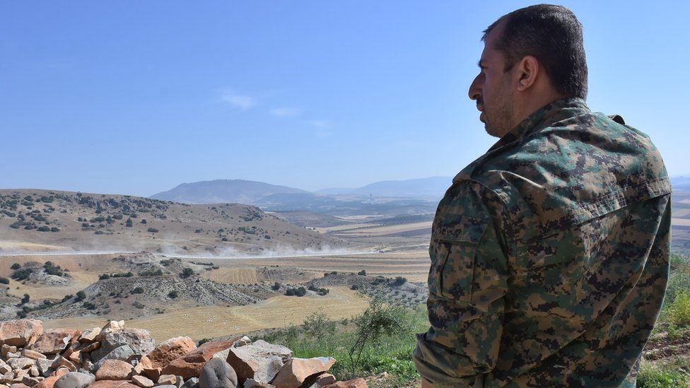 A fighter from the Kurdish People's Protection Units (YPG) monitors in the area of Afrin, along Syria's northern border with Turkey, on June 9, 2017