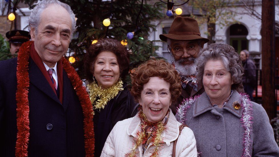 (Left to right) EastEnders actors Leonard Fenton, Mona Hammond, Gretchen Franklin, Tommy Eytle and Elizabeth Kelly celebrate Christmas in Albert Square in 1994