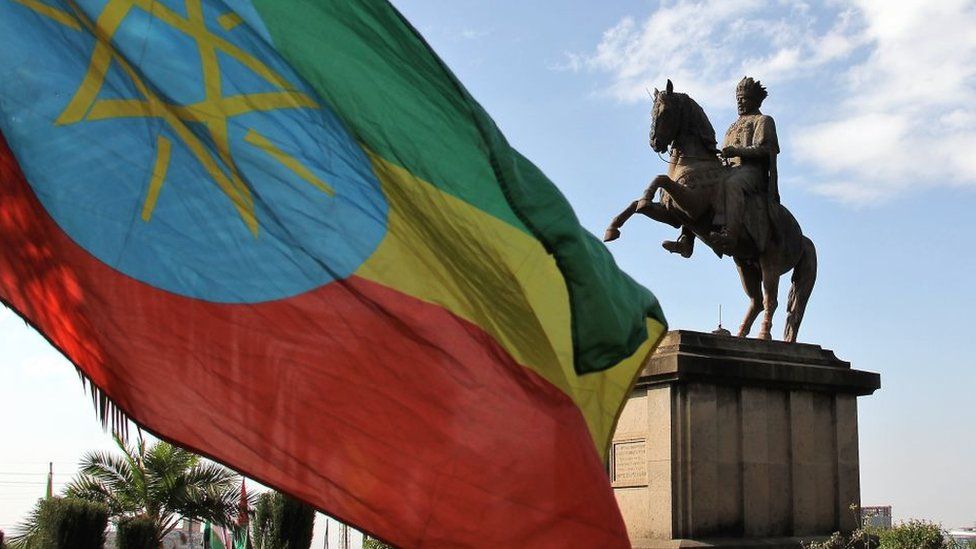 A statue of Menelik II and the Ethiopian flag in Menelik Square, Addis Ababa, Ethiopia