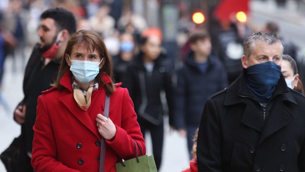 Members of the public wearing face masks as they walk along Oxford Street in London