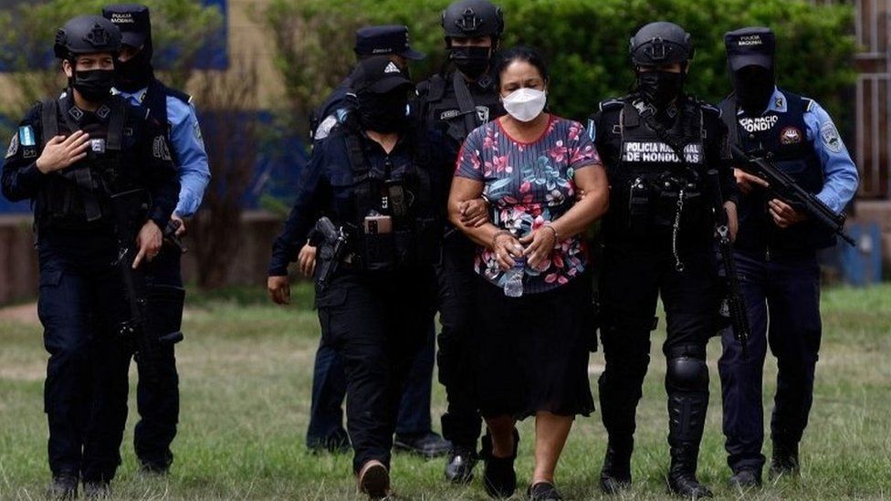 Полицейские сопровождают лидера картеля Херлинду Бобадиллу после запроса Соединенных Штатов об экстрадиции ее и ее сыновей, в Тегусигальпе, Гондурас, 15 мая 2022 г.