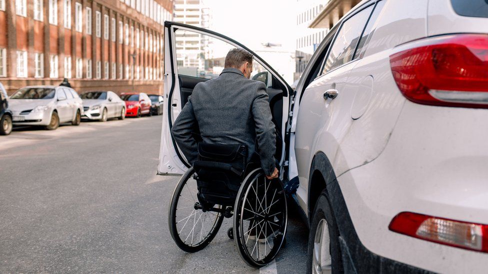 Мужчина в инвалидной коляске садится в Uber