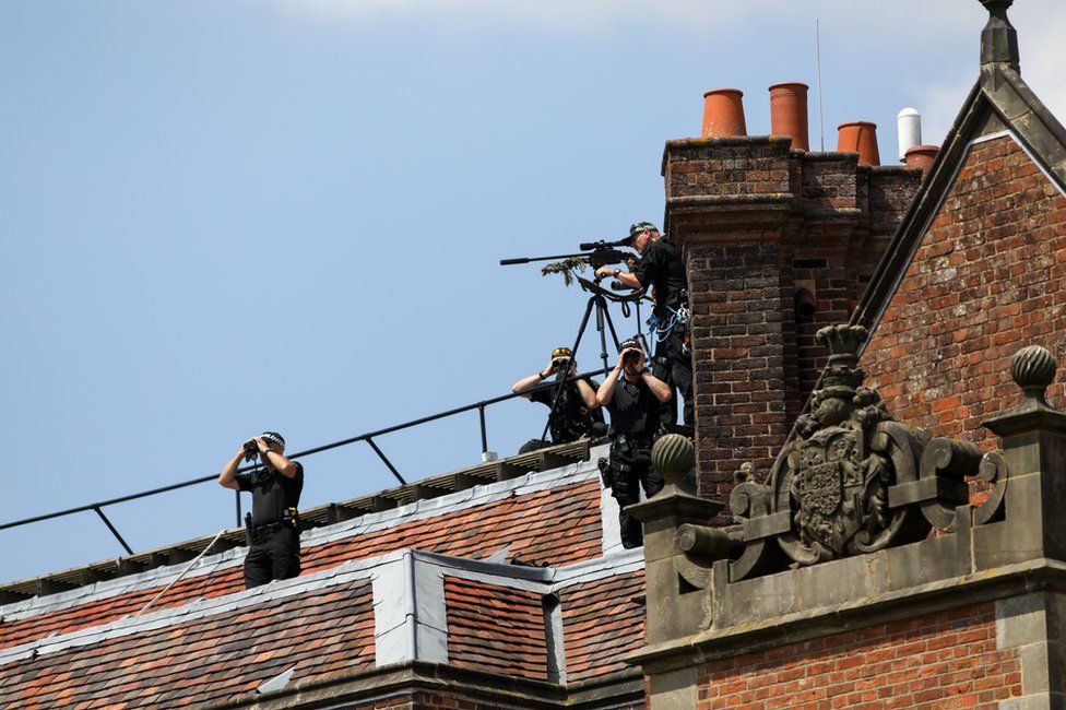 Armed British police officers look out from the roof of Chequers ahead of a joint news conference